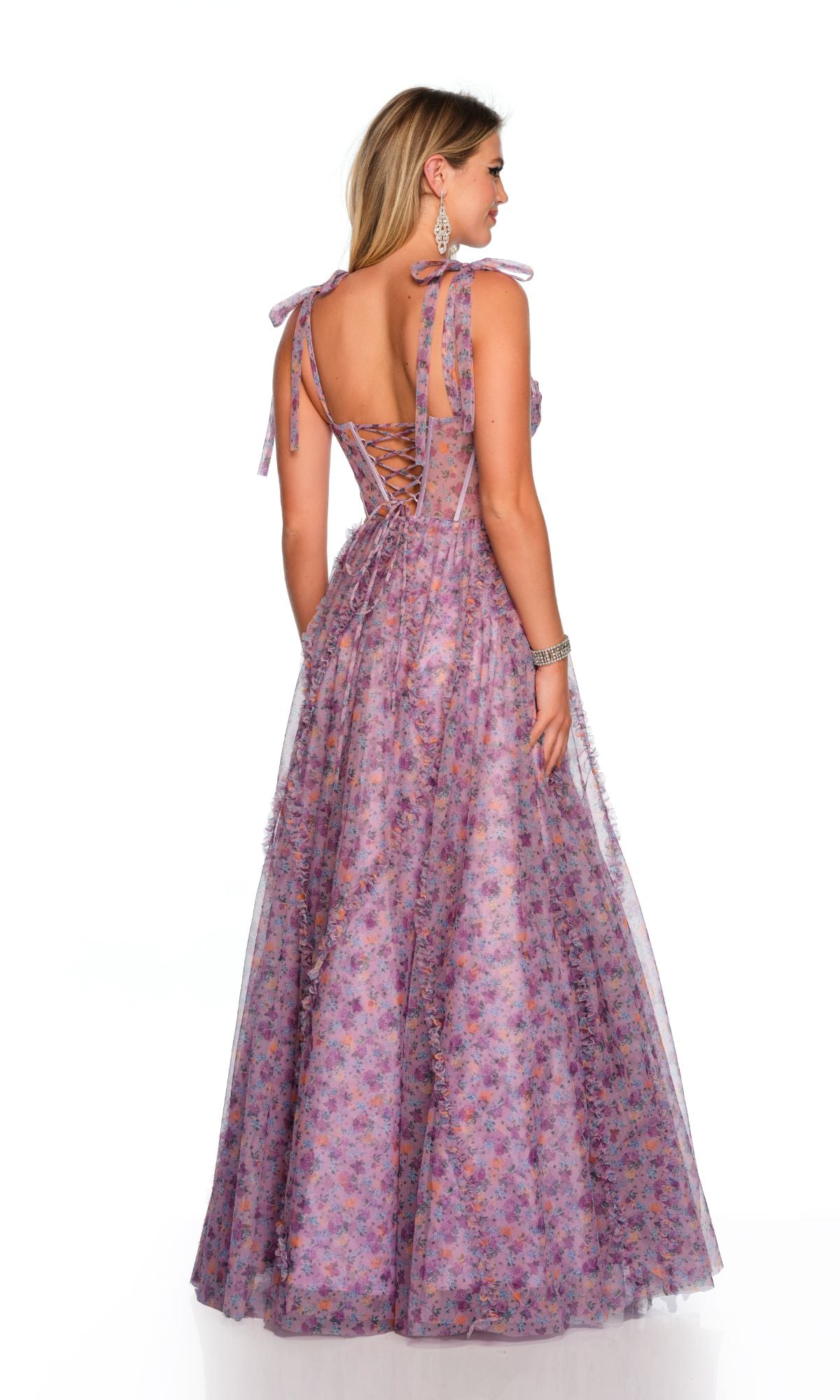 A woman wears the Long Formal Dress 11591 by Dave and Johnny, a sleeveless purple ball gown with a sweetheart neckline, lace-up back, and shoulder tie straps, standing against a plain white background.